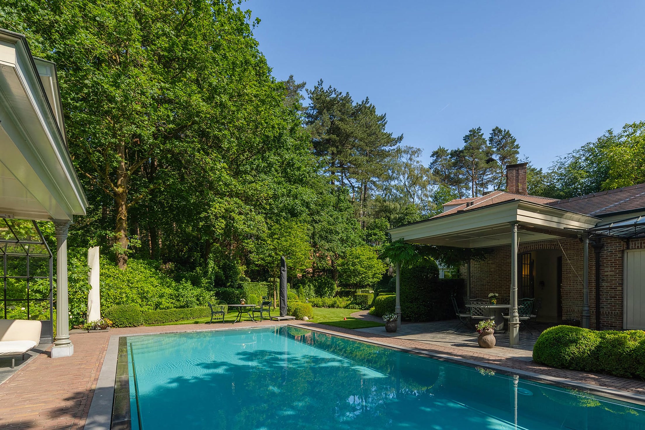 Zwembad met poolhouse in de avondzon